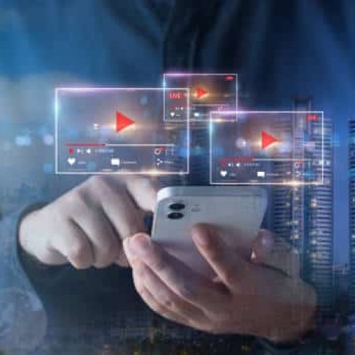 Double exposure of business man using mobile phone and night cityscape